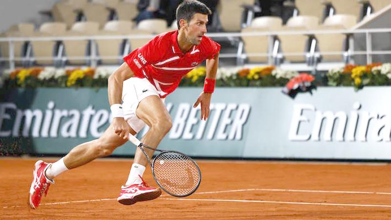 Serbia’s Novak Djokovic runs to return the ball to Greece’s Stefanos Tsitsipas during their men’s singles semi-final tennis match at French Open (AFP)