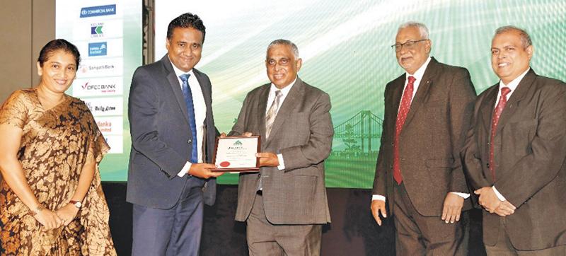 Deputy General Manager, Marketing of People’s Leasing, Laksanda Gunawardena  receives the award for One of the Best Ten CSR and Sustainability Projects from  Trustee of  JASTECA, Athula Edirisinghe.   JASTECA President,  Nimal Perera and  Committee Member Nishan Fernando look on.