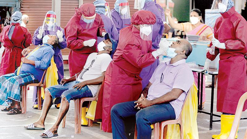 Several new suburbs were added to the new curfew areas list as the new Covid-19 wave intensified this week. Here some random PCR tests being conducted at Gunasinghepura, Colombo. Pic: Eranga Jayawardena