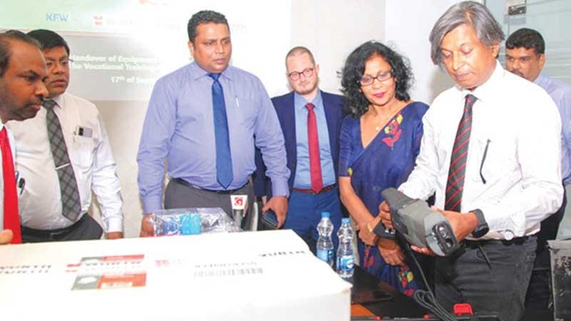 Wurth Managing Director Rohan Amirthiah takes a close look at a chop saw. Chairman, VTA, Damitha Wickramasinghe (centre) and officials look on. 