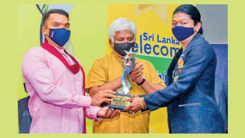 Susanthika Jayasinghe receives the Gold Award from Sports Minister Namal Rajapaksa in the presence of former Sri Lanka cricket captain Arjuna Ranatunga