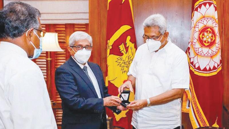 Central Bank Governor Prof. W. D. Lakshman presents the coin to President Gotabaya Rajapaksa