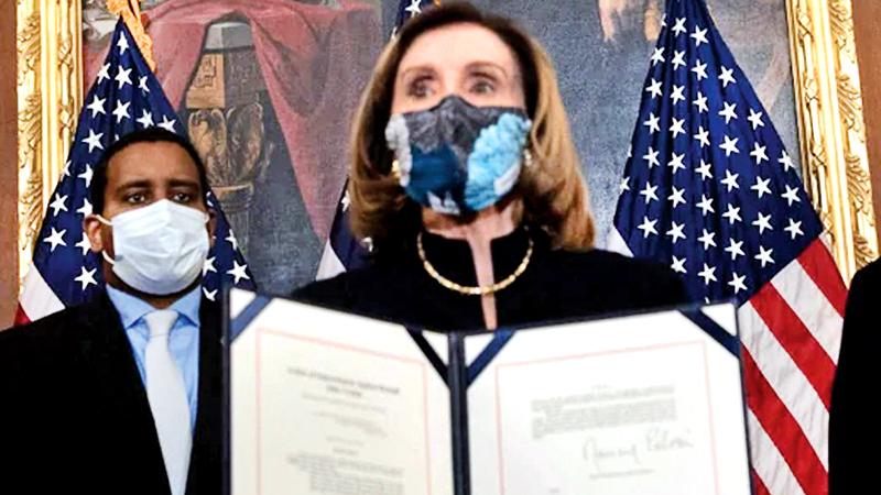 US House Speaker Nancy Pelosi displays the signed article of impeachment against President Donald Trump. The impeachment will now be sent to the Senate for trial