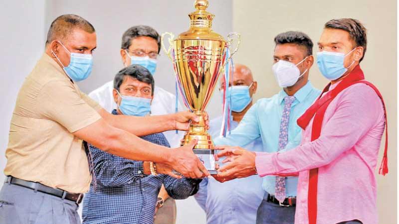Sports Minister Namal Rajapaksa unveiling the “Hambantota League Football Trophy” along with Dr. Chanaka Wijetunga (left) Secretary of the Hambantota District Sports Foundaton. Other officials are also in the picture