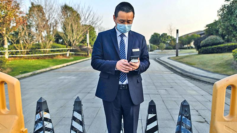 A guard stands at an access area of the Hilton Wuhan Optics Valley Hotel where members of the World Health Organization (WHO) team, investigating the origins of the Covid-19 coronavirus pandemic, are staying after they completed their quarantine in Wuhan, China’s central Hubei province on January 28, 2021.