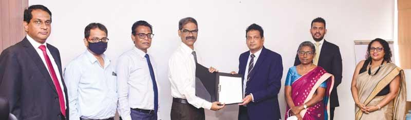 The exchange of the agreement: From left - CEO, NDB Investment Bank, Darshan Perera, Country Head, Indian Overseas Bank, Shameer,  Senior DGM,  NSB, K. Raveendran, CEO, Indian Bank,  Basheer Ahamed,   GM and CEO, NSB, Ajith Peiris, DGM, Credit and International Banking, NSB, Ms. Christine Jesudian, Senior Director, Alpen Capital (ME) Ltd., Dilip Samanthilake and COO, NDB Investment Bank, Ms. Kaushini Laksumanage.