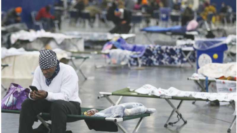  A man looks for information on his cell phone as he rests at the George R. Brown Convention Centre in Houston. AFP