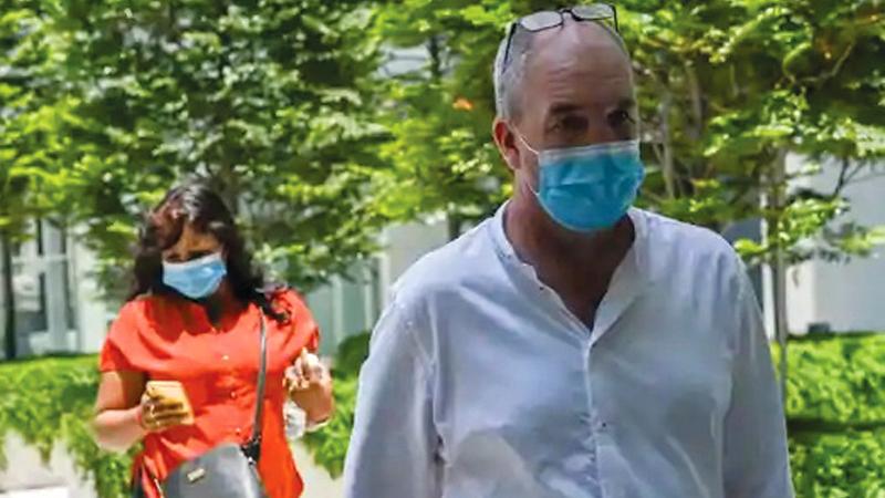 British national Nigel Skea (R) and wife Agatha Maghesh Eyamalai arrive at the State Court in Singapore