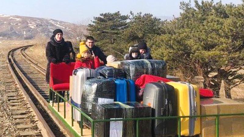 The group of Russian diplomats, which included children, pushed themselves for more than 1km over train tracks