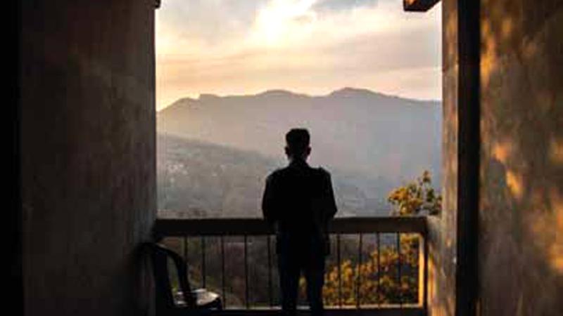 A police officer who fled from Myanmar following a military coup looks out to the mountains from an undisclosed location bordering Myanmar