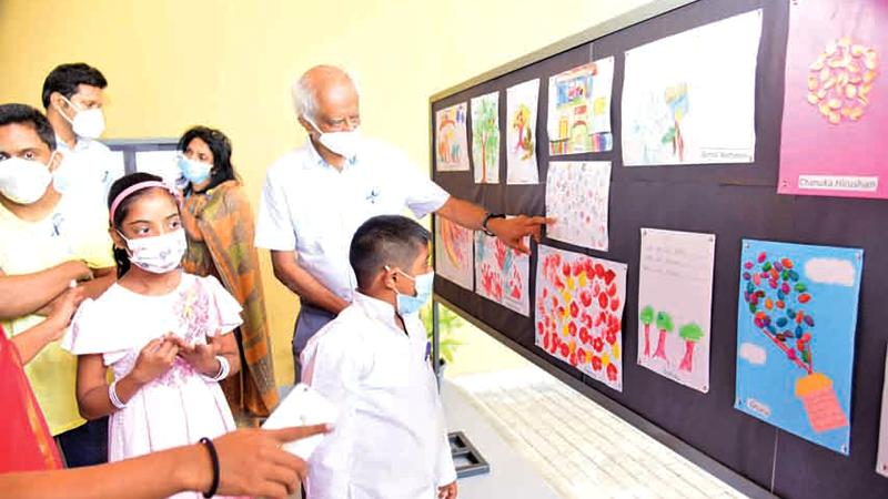 Emeritus Professor of Paediatrics Harendra de Silva points to a drawing by children with special needs