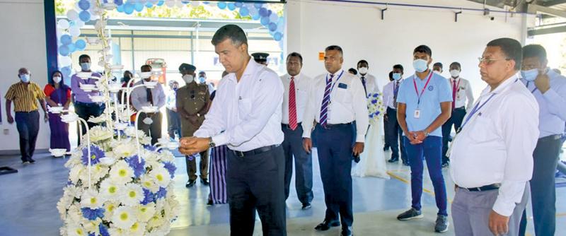 Rohana Dissanayake, Chairman, David Peiris Group  lights the  oil lamp while DPMC, Director (Vehicle Sales) Nalaka Madugalla (centre) and DPMC Director (Parts and  Accesories) Jayantha Ratnayake (right) looks on.