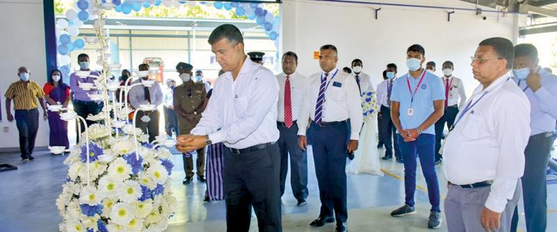 Rohana Dissanayake, Chairman, David Peiris Group lights the oil lamp while DPMC, Director (Vehicle Sales) Nalaka Madugalla (centre) and DPMC Director (Parts and Accesories) Jayantha Ratnayake (right) looks on.