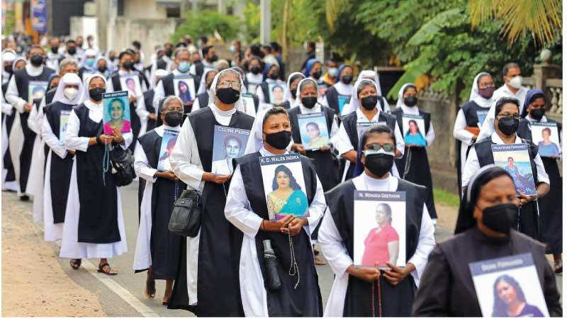 Catholic priests and nuns carry photos as they remember the victims killed in the 2019 Easter Sunday bombings. The walk to remember the terror victims began at Maris Stella College, Negombo at 3.00pm on Wednesday (21) and ended at the Katuwapitiya Church. Pix by Sulochana Gamage and Saman Sri wedage