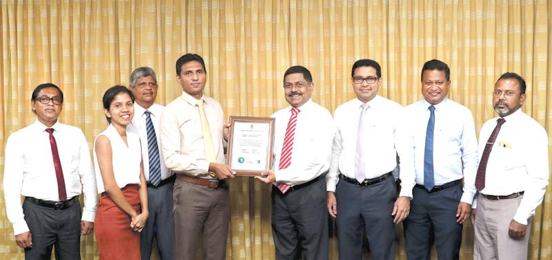 Commercial Bank›s Managing Director S. Renganathan, COO Sanath Manatunge and AGM Services, Chinthaka Dharmasena (fourth, third and second from right) and senior bank officers receiving the certificate from officials of the  Sri Lanka Climate Fund.