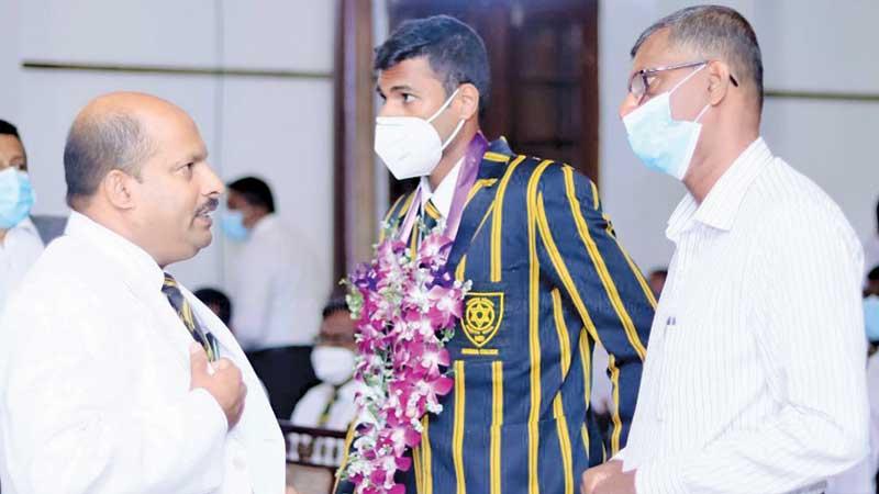 Mahinda College principal Gamini Jayawardena chats with Navod Paranavithana and his father Kelum at the school felicitation ceremony