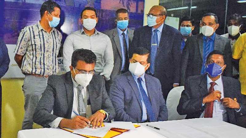 Director General Sports Development Ministry of Sports Amal Edirisuriya (left) and Kanchana Jayaratne (right) exchanging the MoU documents in the presence of Minister Namal Rajapaksa