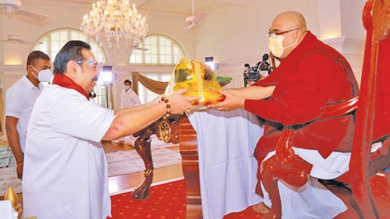 Prime Minister Mahinda Rajapaksa offers Atapirikara to the Most Ven. Kolonnawe Sri Sumangala Thera after the end of the Ama Dham Sisila Dhamma sermons at Temple Trees on Vesak Poya Day (May 26)