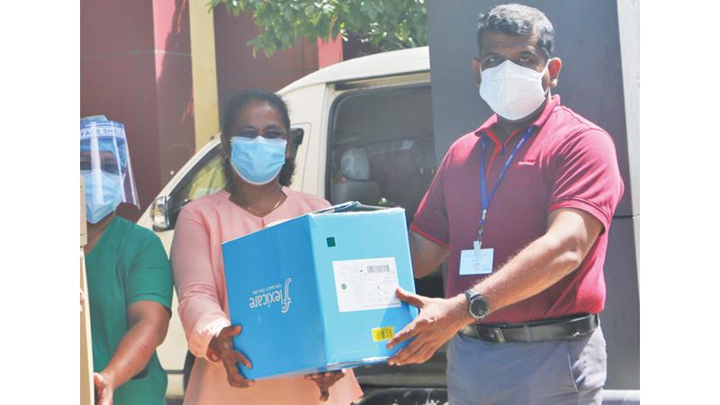 Group HR and Admin Manager Rohana Wijesooriya and  – Group Talent Development Manager, Dimuth Liyanagama present ventilation machines to  Deputy Director of Nagoda General Hospital, Dr. Chintha Gunarathna.