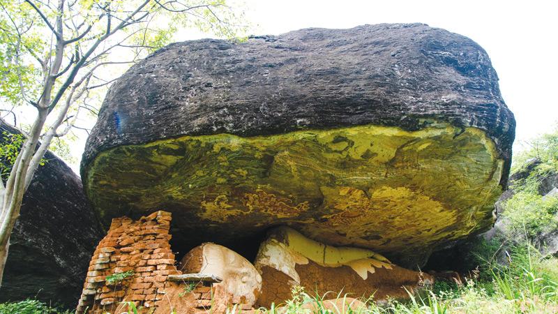 The Mailla rock cave with the reclining Buddha statue damaged by treasure hunters later retouched by someone or group