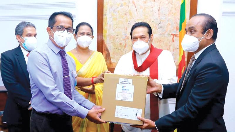 People’s Leasing Chairman Sujeewa Rajapaksa and CEO Shamindra Marcelline make a token presentation to Prime Minister Mahinda Rajapaksa.