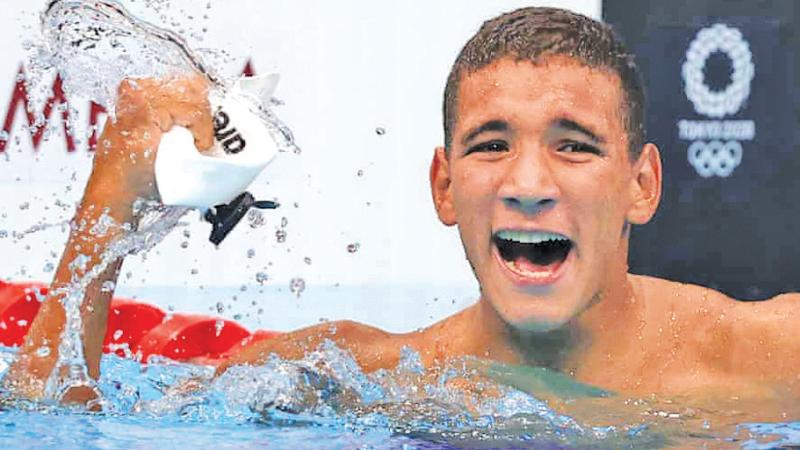 Tunisian swimmer Ahmed Hafnaoui celebrates winning his shock Olympic gold