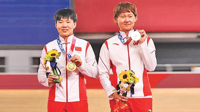 Shanju Bao and Tianshi Zhong poses with the gold medal after the Women’s team sprint finals of the Track Cycling at the Tokyo Olympics