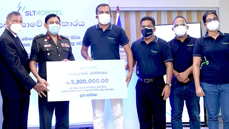 General Manager (Western Province) Chethana Attanayake and General Manager, Marketing Services of SLT, Anuruddha Suriyarachchi present the PCR machine to Vice Chancellor of General Sir John Kotalawala Defence University, Maj. Gen. Milinda Peiris and Executive Director of KDUH, Dr. Jayan Mendis. Officials of KDUH and SLT-Mobitel look on.