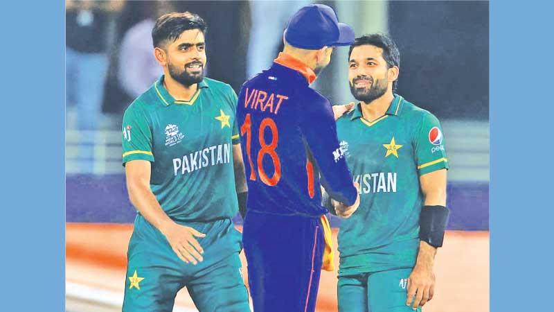 Indian captain Virat Kohli meets his Pakistan counterpart Babar Azam (left) and Mohammad Rizwan in a friendly chat