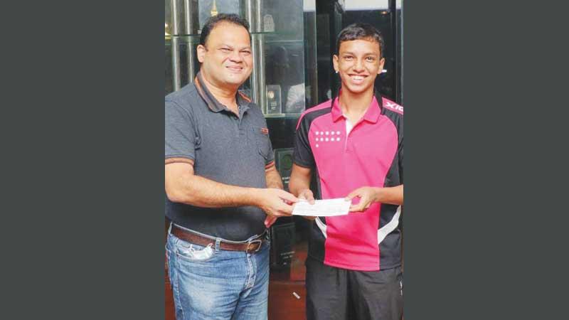 Amoris Sellar (left) Crysbro Senior Marketing, Manager presenting travelling assistance of Rs. 125,000 to table tennis player Senura Silva