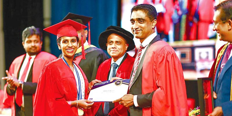 Chairman and Managing Director of the ESOFT Group Dr. Dayan Rajapakse presents a certificate to a graduate