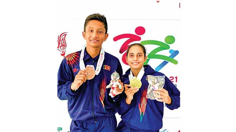 Naveed Raheem bronze medal swimmer and gold medalist Galina Basnayake pose for a ceremonial picture after the medal-awarding ceremony 