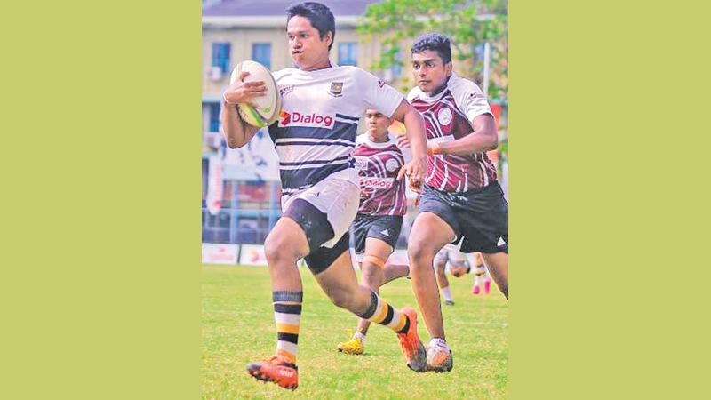 Mahanama College player Dhasith Nipuna makes a break out-running V Vishmatha of CWW Kannangara MV in their Dialog inter school rugby Sevens championship match at the Royal College ground in Colombo yesterday