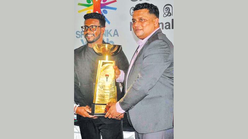 SLFYC Secretary Dilshan Chathuranga Jayakuru (left) and NYSC Director General Damitha Wickramasinghe displaying the Champions Trophy at a press conference (Picture by Sudath Malaweera)