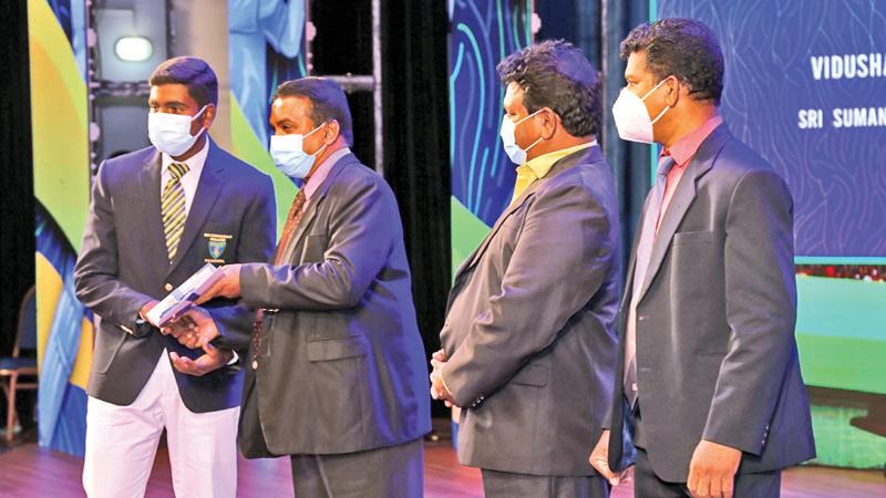 Division II Best Batsman runner up Pulasthi Anuradha Atapattu of Kegalu Maha Vidyalaya receiving his cash Award and Certificate from Editor-in Chief Silumina Dharman Wickremaratne. Also in the picture are Dinamina Editor Gamini Jaylath and Pictures Editor Wimal Karunatilleke