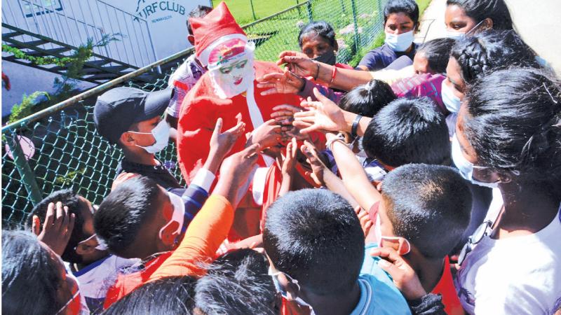 Children gather around Santa who lit up their day that marked the Royal Turf Club’s humanitarian project in Nuwara Eliya