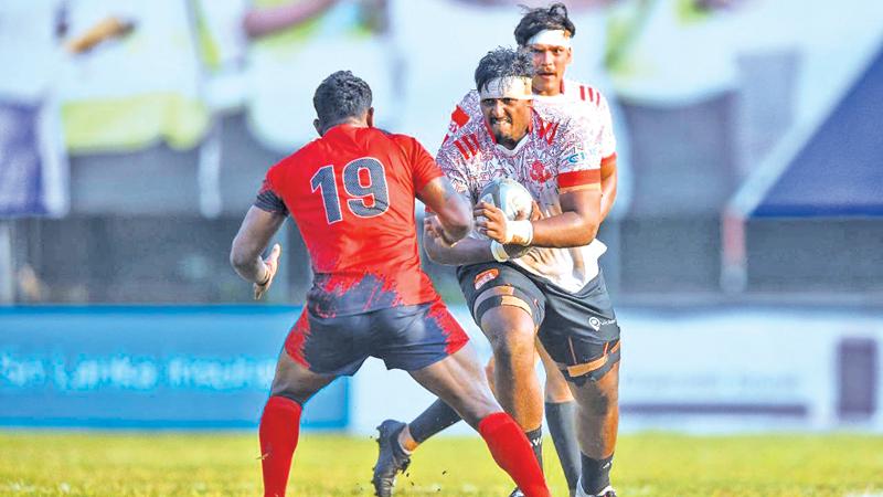 CR’s open-side flanker Imanka Ariyapala attempts to unleash a tackle on CH and FC flanker Shehan Dias