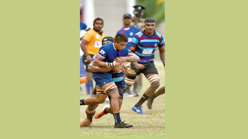 Police SC flanker Vageesha Weerasinghe is held by an Air Force SC defender