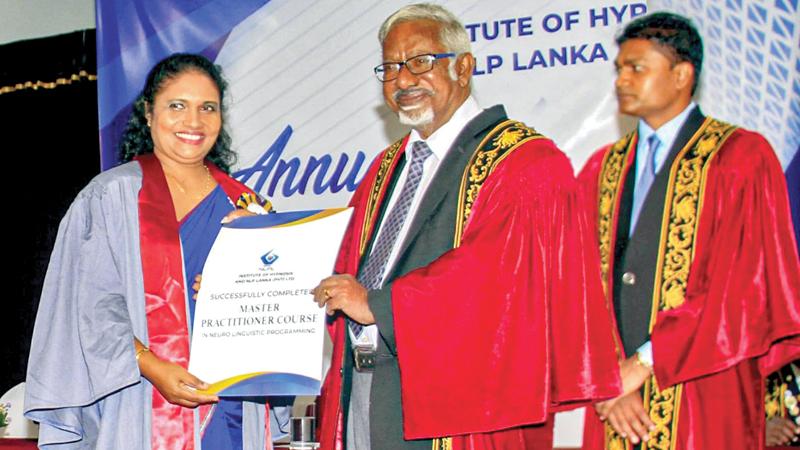 NLP Practitioner R.C. Rathnayake receives an award from chief guest Prof. S. Sandarasegaram. NLP trainer Jaliya Rathnayake looks on. Pic: Saliya Rupasingha