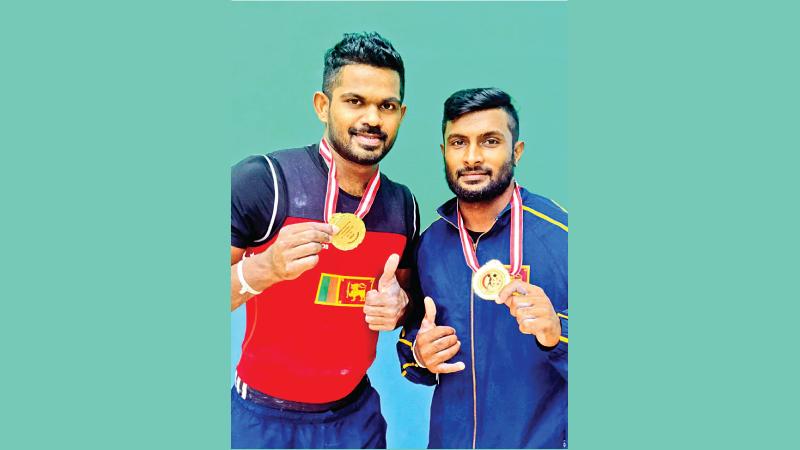 Sri Lanka’s Indika Dissanayake (left) and Chaturanga Lakmal pose with their gold medal
