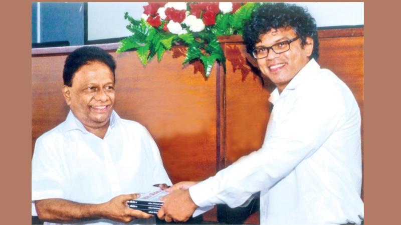 Handing over the volume by the Chairman of SLPC Mahinda Pathirana to Minister of Mass Media Dullas Alahapperuma