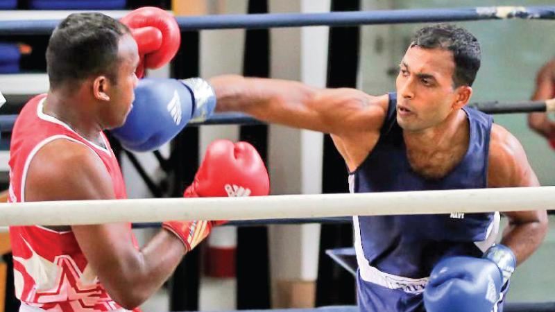 Navy’s WMGKGI Ariyaratne (blue) lands a solid right on Air Force’s WGNC Wijenaga in the middle weight (under 75kg) final