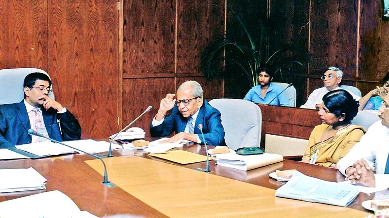 Author of ‘Reminiscences of The Central Bank of Sri Lanka’, the late Edmund Eramudugolla (Centre) addresses the then Governor of the Central Bank Sunil Mendis (on left) and the gathering at the book presentation event at the Board Room of the Central Bank on September 20, 2004