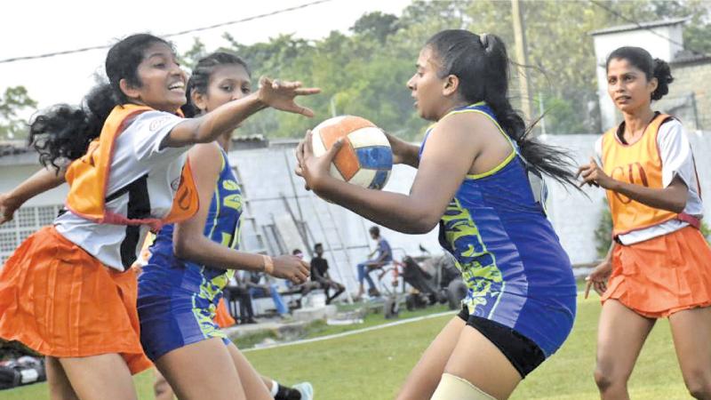 Police SC (blue) and Colombo Malay Cricket Club players battle for the ball in the netball match at the Padang in Slave Island yesterday