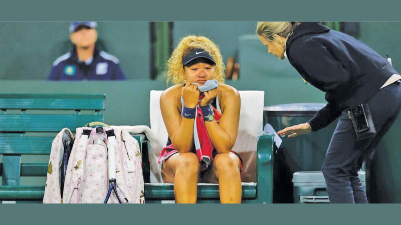 A court official talks to Naomi Osaka