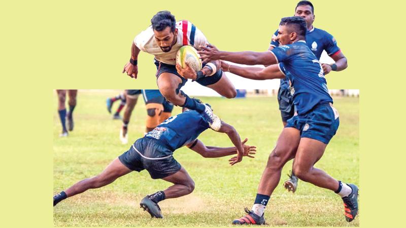 In this file photo Kandy SC centre Kavindu Perera jumps over the Police SC defence in their last week’s outing in the League at Police Park in Colombo