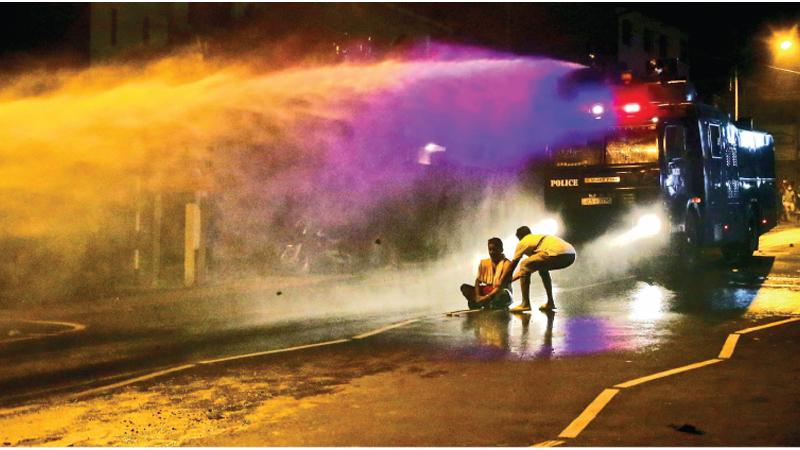 Protestor blocks a police riot control vehicle