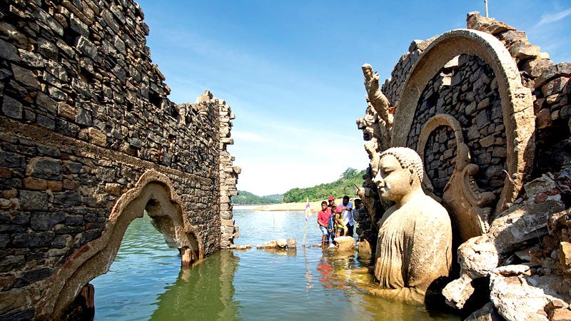 Once the water level drops, a Buddha statue crumbling fast emerges from the bottom of the reservoir