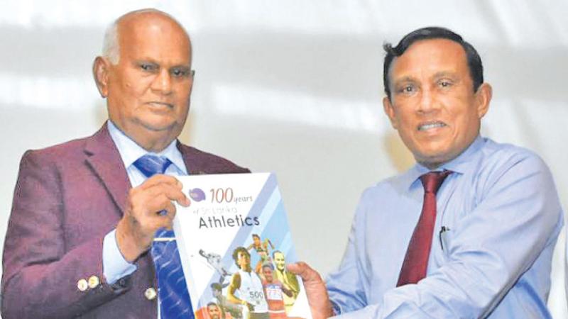 Olympic marathoner Wimalasena Perera (left) receiving the book from Palitha Fernando, president of Sri Lanka Athletics at its launch on Thursday