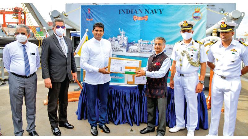 Indian High Commissioner Gopal Bagle presents the stock of drugs to Health Minister Prof. Channa Jayasumana while Sri Lankan and Indian Naval officials look on